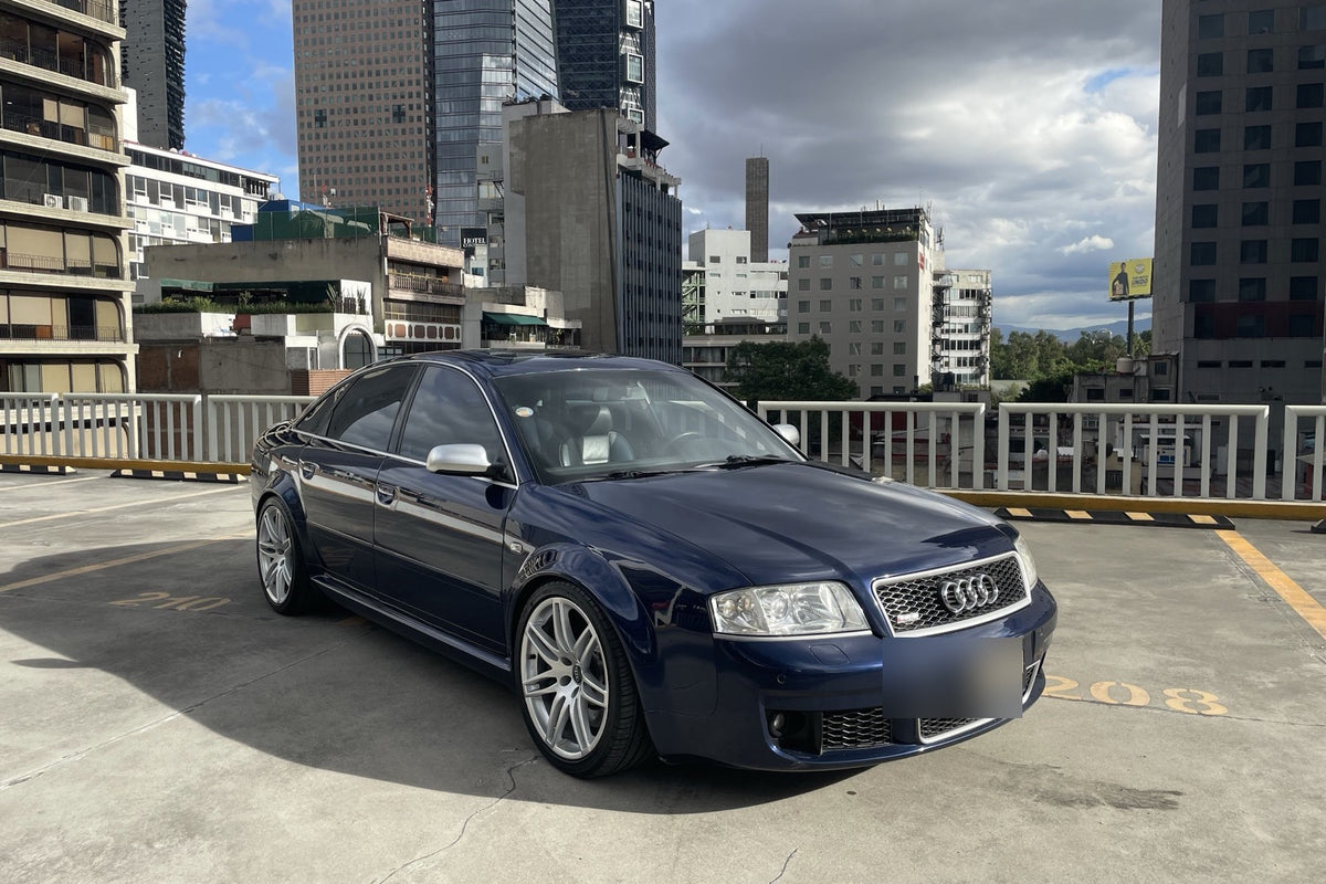 Audi RS6 2004, frontal tres cuartos con skyline de la ciudad